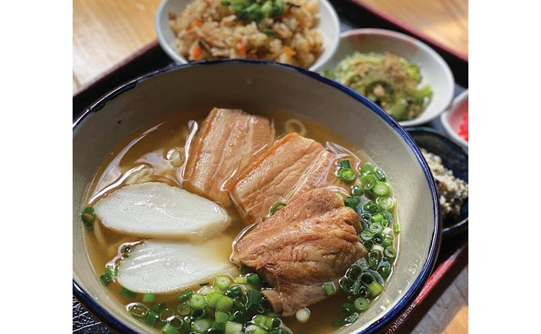 人気の「伊豆味そば」（手前）と、沖縄の炊き込みご飯「じゅーしー」（左奥）。（写真提供：伊豆味そば）