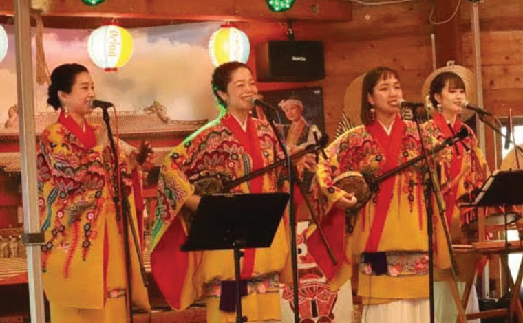 澄んだ歌声と明るい笑顔で沖縄の民謡やポップスを披露するいなぐんぐゎの4人。左から2番目がMarieさん（写真提供：いなぐんぐゎ）
